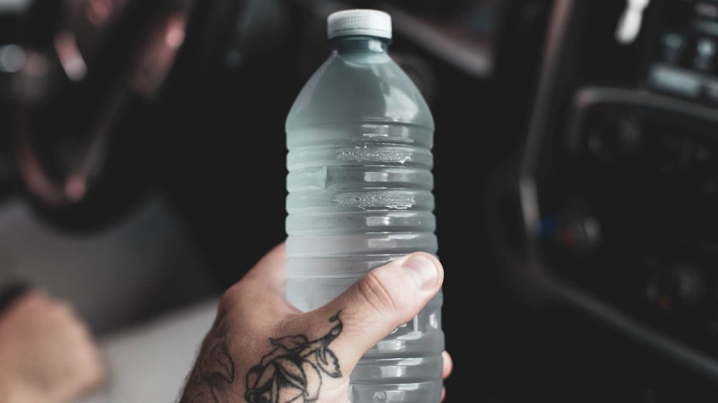 A hand grasping a reusable water bottle, staying hydrated.